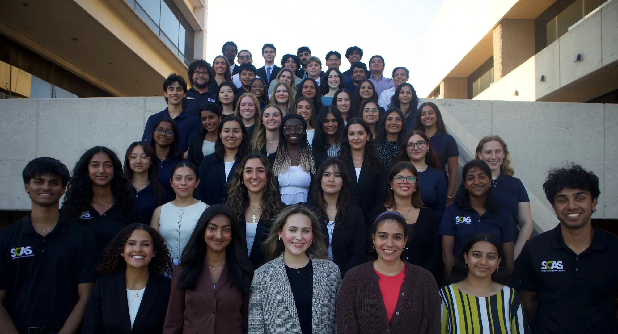 Members of the Student Council of Arts & Sciences gathered together, many wearing SCAS polos.
